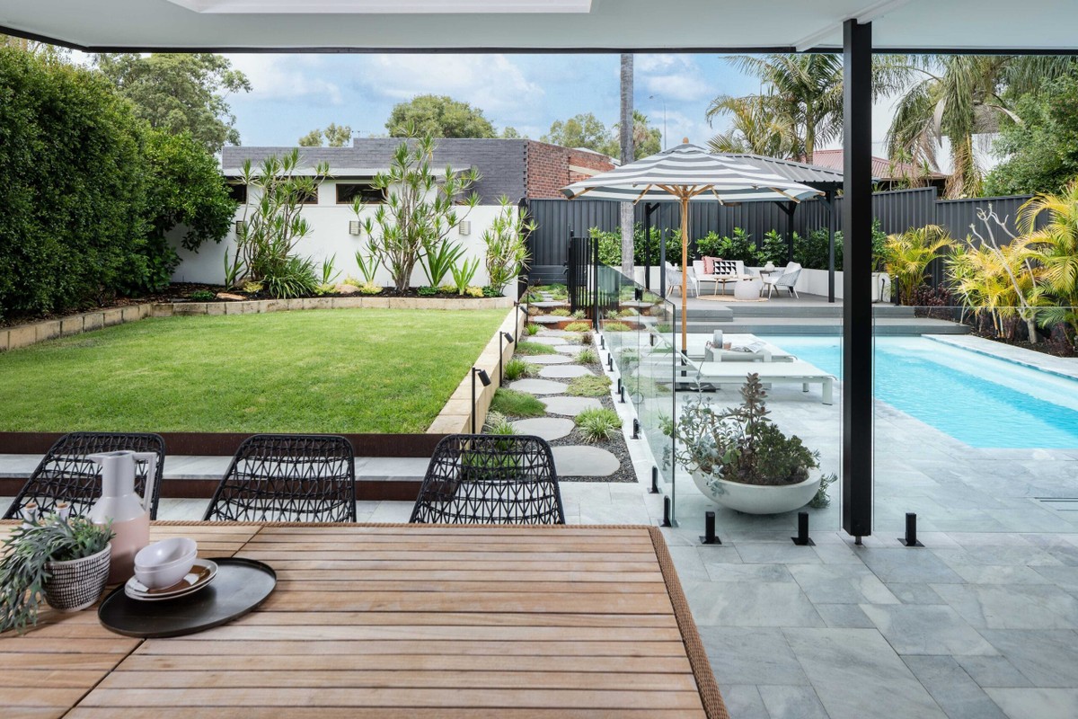 A beautiful kitchen area with view of outdoor pool Revell Landscaping