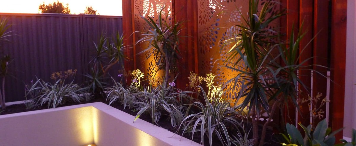 Garden landscape featuring lighting & retaining walls